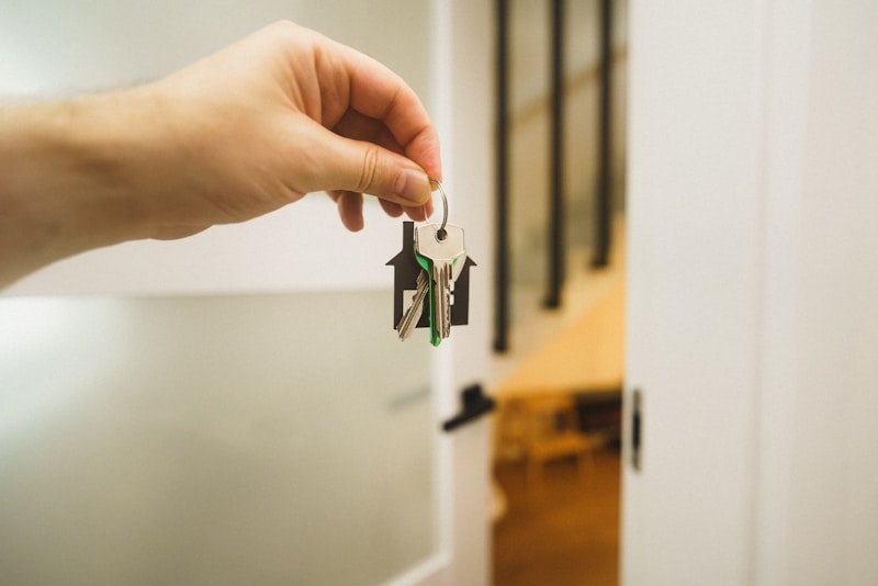 Hand holding a key to a front door
